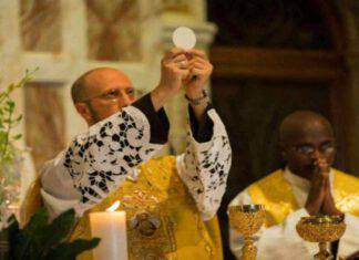 sacerdote che eleva l'eucarestia