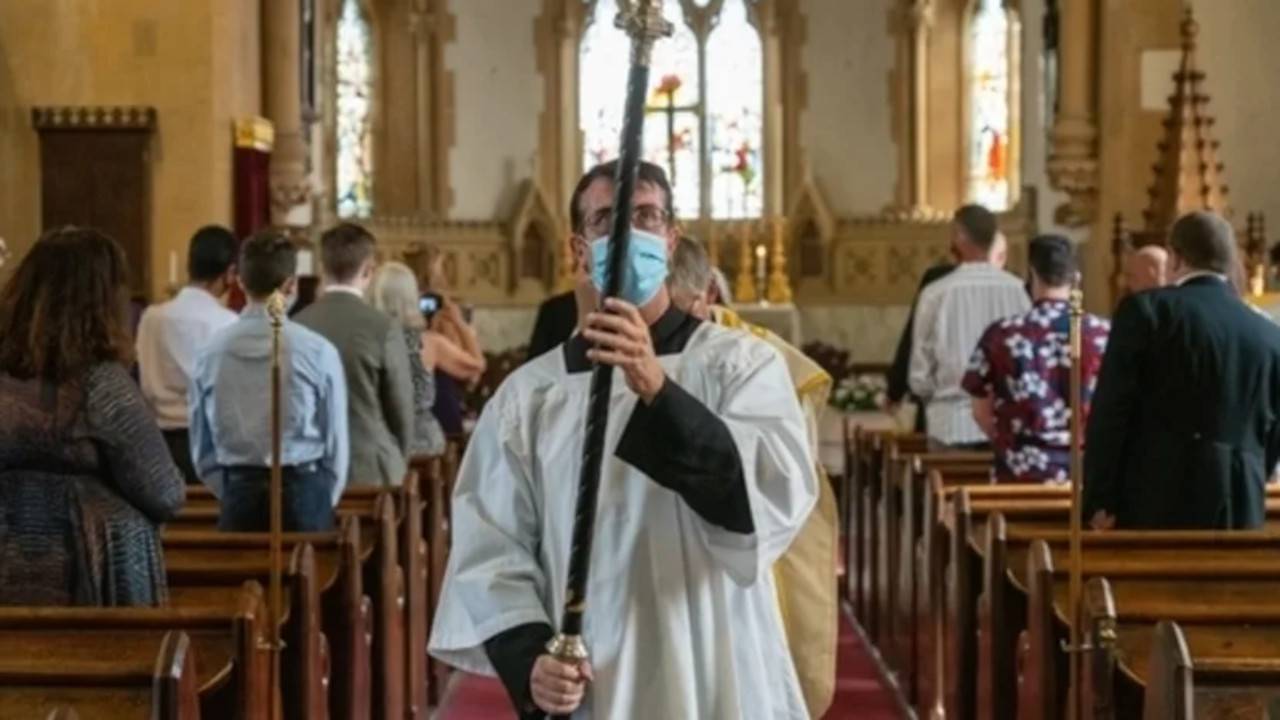 Fedeli in chiesa con mascherina
