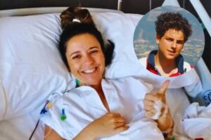 la donna malata a letto sorridente con accanto la foto di carlo acutis