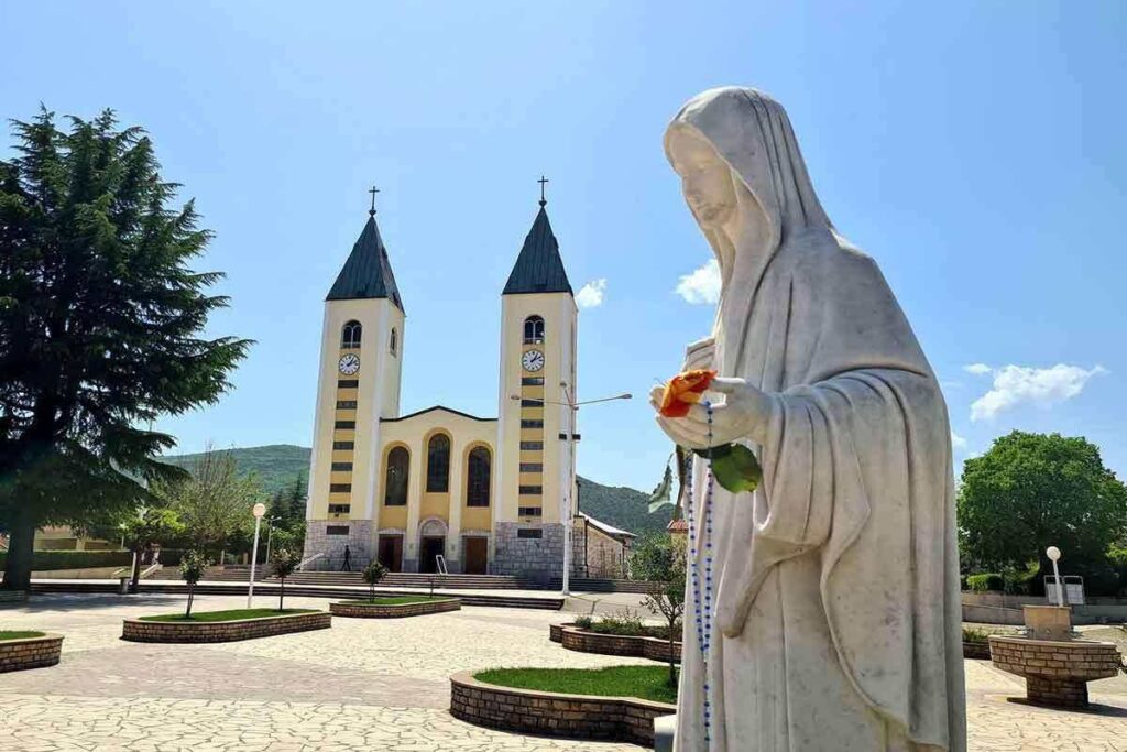 madonna di medjugorje con sfondo chiesa di san giacomo