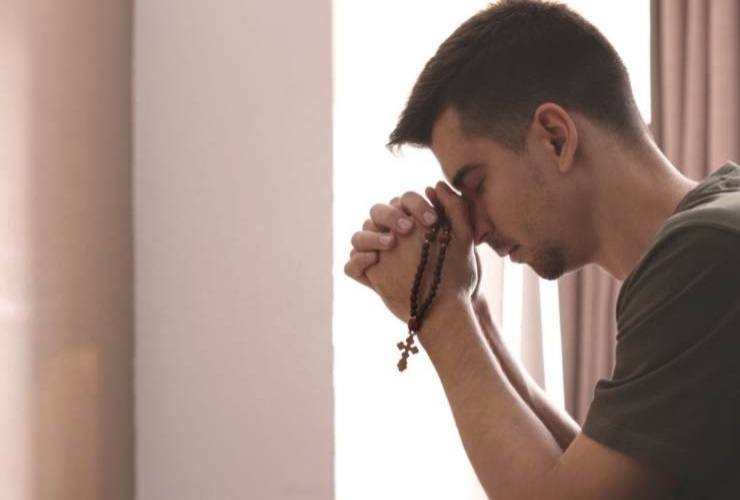 ragazzo che prega il rosario