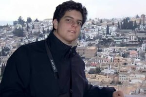 Carlo Acutis con città sullo sfondo