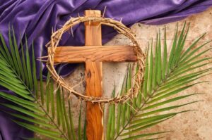 la croce di gesù con una corona di spine e, su sfondo, delle palme