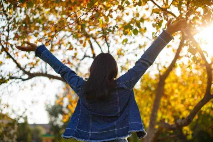 ragazza che alza le mani felice di spalle