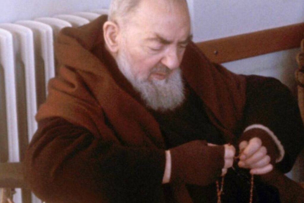 padre pio seduto in preghiera