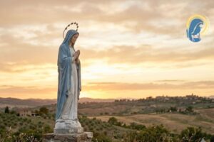 la statua della madonna con sfondo al tramonto