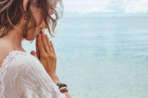 donna che prega con sfondo mare