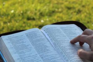 bibbia aperta e una persona che segue col dito