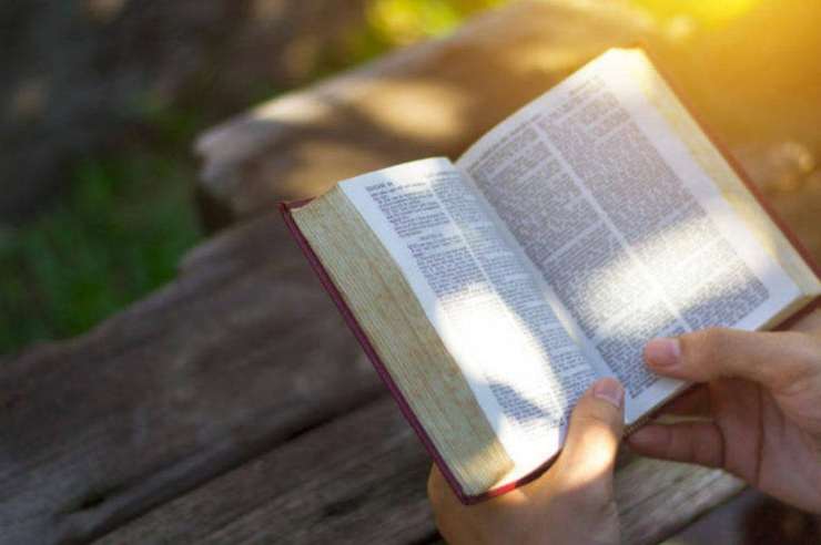 bibbia aperta in mano ad una persona