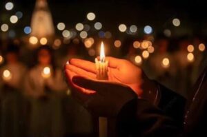 candela accesa fra le mani di una persona